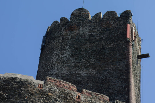 Stone tower with crenellated parapet against clear blue sky