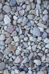 Pebbles of different sizes and colors create a textured surface outdoors