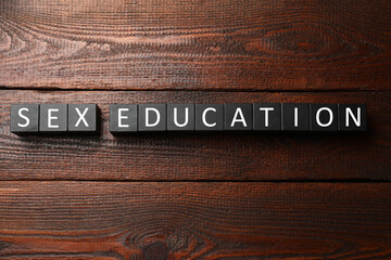 Phrase Sex Education made with cubes on wooden table, top view