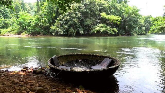 A coracle boat moored on the banks of Kallar river at Adavi, Pathanamthitta, Kerala, India | Adavi Eco Tourism entertainments