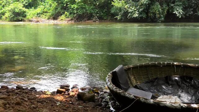 A coracle boat moored on the banks of Kallar river at Adavi, Pathanamthitta, Kerala, India | Adavi Eco Tourism entertainments