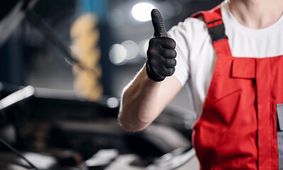 Man mechanic giving thumbs up in workshop, car repairs service.