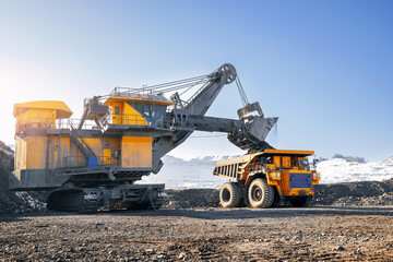 Process work on open pit mine with big truck, sunlight