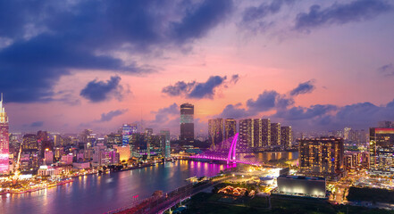 Aerial panorama of Ho chi minh or Saigon city at sunset in Vietnam, illuminated skyscrapers with sunlight drone view