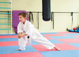 Karate boy doing stretching at workout.Child in kimono. Martial arts. 極真会(Karate Kyokushin)	
