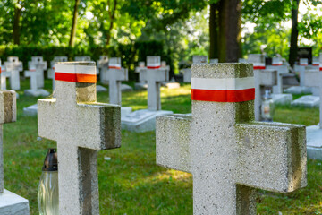 Military cemetery in Kalisz from World War I, concrete crosses with white and red bands. A solemn memorial honoring fallen soldiers in Poland.