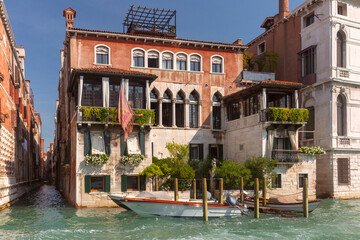 Traditional Venetian canal house with balconies and moored boat on Grand Canal in Venice Italy