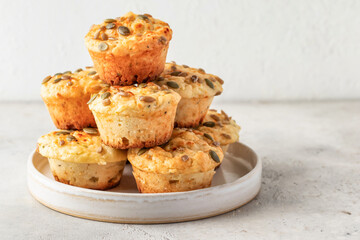 Savory zucchini muffins with cheese and seeds on a plate on white table background isolated. Healthy and quick morning breakfast