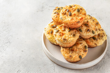 Savory zucchini muffins with cheese and seeds on a plate on white table background isolated. Healthy and quick school morning breakfast