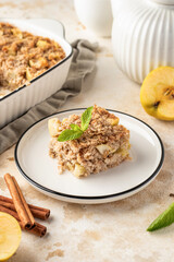 Slice of apple pie baked oatmeal in a plate on kitchen table background