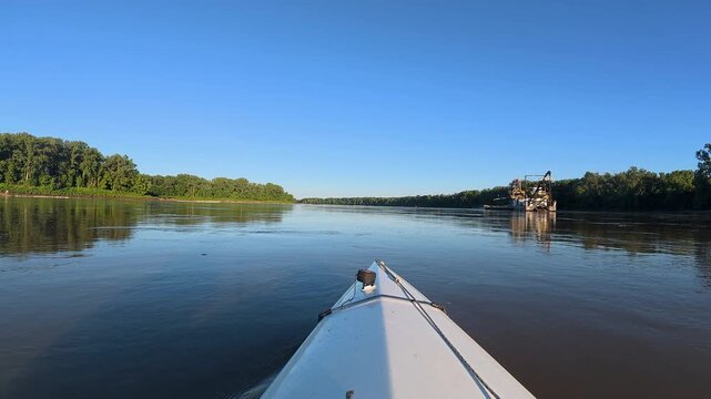 paddling on the Missouri River and approaching a sand dredge near Jefferson City, MO - POV from kayak or canoe
