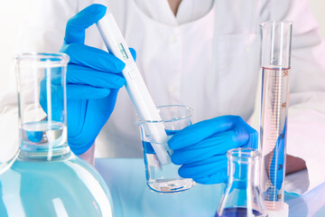Scientist examining water with nitrate tester at white table in laboratory, closeup