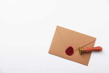 Envelope with wax seal and stamp on white background, top view. Space for text