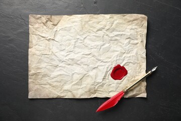 Crumpled paper with wax seal and fountain pen on black table, top view
