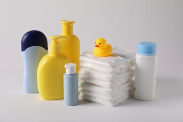 Baby accessories and body care products on light grey background