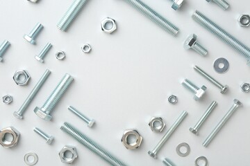 Metal bolts and nuts on white background, flat lay. Space for text