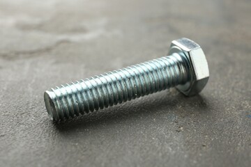 One metal bolt on grey table, closeup
