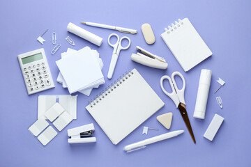 White notepad and other stationery on violet background, flat lay. Space for text
