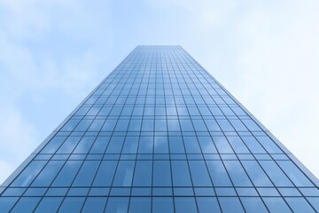 Fototapeta premium Skyscraper Angled View with Glass Facade Reflecting Sky and Clouds, Modern Architecture and Urban Landscape