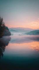 Fototapeta premium Serene Lake Landscape at Sunrise with Fog, Mountains, and Vibrant Sky Reflections Vertical