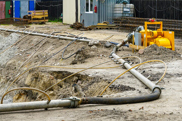 Construction site with dewatering pump and pipes draining groundwater for excavation stability
