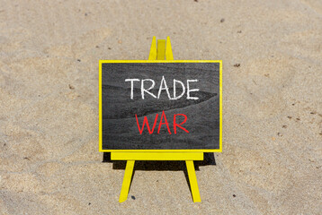 Trade war symbol. Concept word Trade war on beautiful black blackboard. Beautiful sand beach...