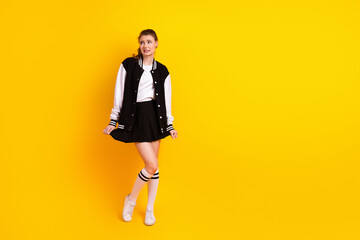 Young stylish student woman in casual outfit posing on vibrant yellow background expressing...