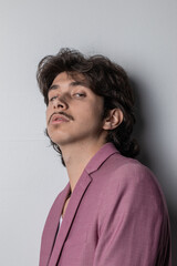 Obraz premium Studio photo of a young man wearing a pink suit. Vertical photo