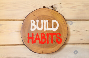 Build habits symbol. Concept word Build habits on beautiful wooden circle on wooden wall. Beautiful...