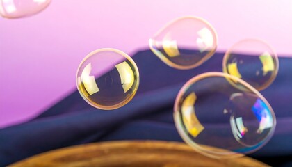 Multicolored soap bubbles float against a backdrop of contrasting purple and navy fabrics.