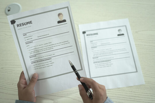 Asian businessman employer is holding resume to hire job applicant, analyzing the applicant's data and job history before nterview, recruiting new employees, recruitment, employment and HR concept.