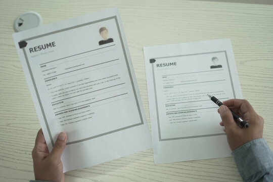 Asian businessman employer is holding resume to hire job applicant, analyzing the applicant's data and job history before nterview, recruiting new employees, recruitment, employment and HR concept. - Powered by Adobe