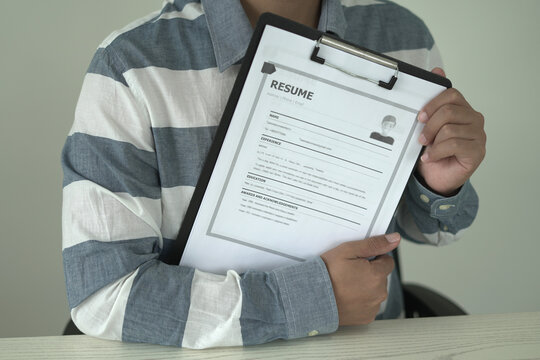 Asian businessman employer is holding resume to hire job applicant, analyzing the applicant's data and job history before nterview, recruiting new employees, recruitment, employment and HR concept. - Powered by Adobe