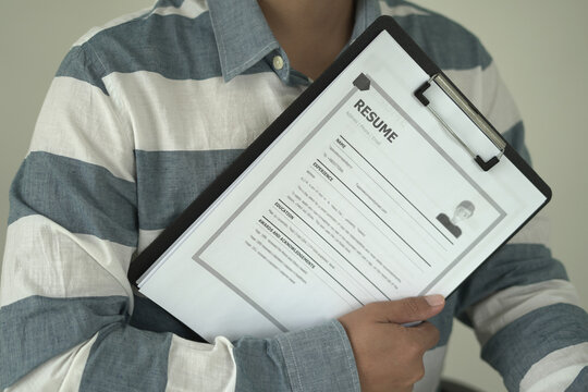 Asian businessman employer is holding resume to hire job applicant, analyzing the applicant's data and job history before nterview, recruiting new employees, recruitment, employment and HR concept.