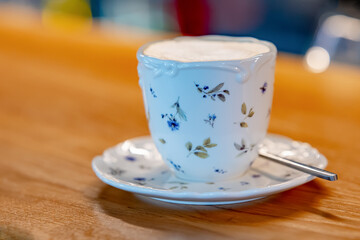Beautiful white cappuccino cup with a spoon on a wooden breakfast tray 