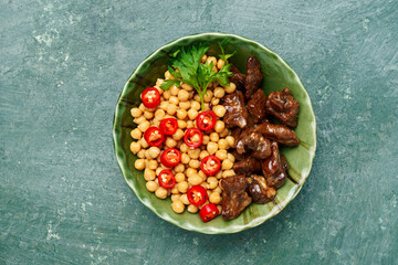 juicy grilled meat served with chickpeas, red chili pepper, and fresh herbs. Rich textures and vibrant colors highlight the freshness