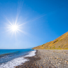 stony sea beach with huge stones near a coast at the summer sunny day