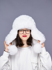Young woman in cozy hat posing in studio