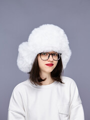 Girl wearing a fluffy white hat in studio