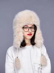 Girl wearing a stylish fur hat in studio