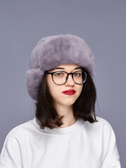 Girl posing in a hat in a studio setting