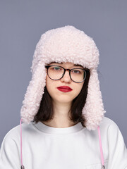 Girl wearing a fluffy hat poses indoors