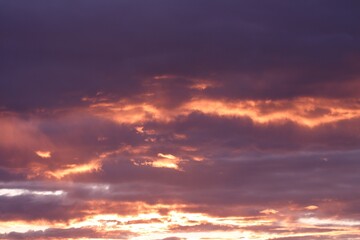 Obraz premium A dramatic sunset paints the sky with shades of purple and orange, highlighting the clouds. Concept of: Atmospheric beauty.