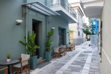 Narrow street with outdoor café seating and pastel buildings in Nafplio Greece