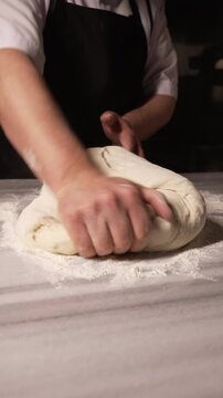 The image shows a chef expertly shaping dough on a flour-covered surface, highlighting the intricate processes and dedication involved in baking fresh bread and pastries, fa01