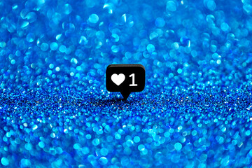 Black notification icon with white heart and number one on blue glitter background social