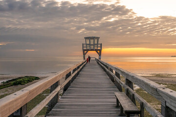 Luc-Sur-Mer, France - 08 07 2025: View of the wooden pier in front of the sea named Fisherman's Pier at sunrise