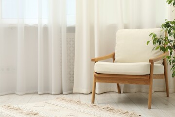 Stylish furniture near window with curtains in living room. Interior design