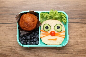 Open lunch box with delicious food on wooden table, top view