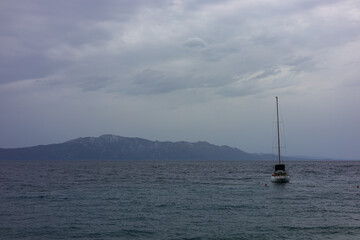A single sailing yacht against a calm sea at sunset in the twilight. Seascape with a sense of...
